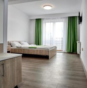1 dormitorio con 1 cama y cortina verde en Márti en Odoreu