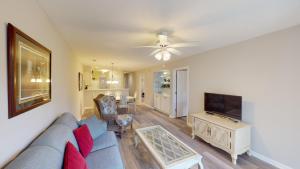 a living room with a blue couch and a tv at Scenic Serenity 2BR Villa with Private Balconies in Pawleys Island