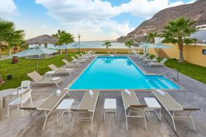 een zwembad met ligstoelen en een resort bij City Express by Marriott La Paz in La Paz