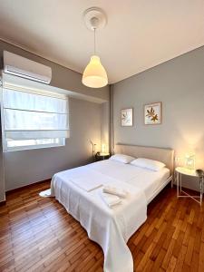 カラマタにあるFeel at home - Kalamata - Central 1の大きな白いベッドと窓のある寝室