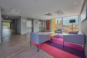 a living room with a couch and chairs and a table at City Express by Marriott Puebla Centro in Puebla