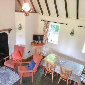 a living room with a table and chairs and a television at Louisburgh Cottages in Louisburgh