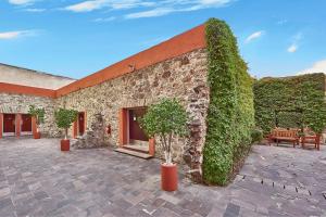 un edificio de piedra con plantas a su lado en City Express by Marriott Puebla Centro, en Puebla