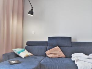 sala de estar con sofá azul y almohadas en Republiki, en Cracovia