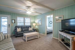 een woonkamer met een bank en een flatscreen-tv bij The Skelton House Your Coastal Oasis in Litchfield Beach in Pawleys Island