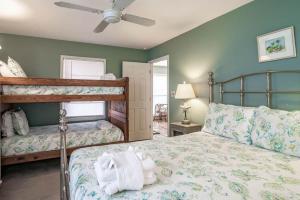 een slaapkamer met 2 stapelbedden en een plafondventilator bij The Skelton House Your Coastal Oasis in Litchfield Beach in Pawleys Island