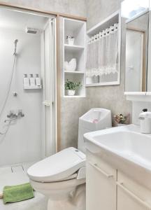 biała łazienka z toaletą i umywalką w obiekcie KOSUMOSU w Tokio