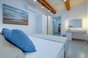 a white bedroom with a bed and a sink at Kapitali 33A in Valletta