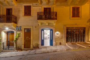 a building with a blue door on a street at Kapitali 33A in Valletta