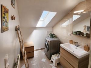 a bathroom with a washing machine and a sink at Akela - Appartement à 12mn de Disneyland Paris ! in Bussy-Saint-Georges