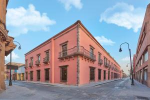 um edifício vermelho no lado de uma rua em City Centro by Marriott San Luis Potosi em San Luis Potosí