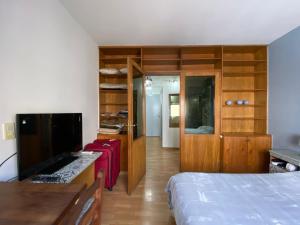 1 dormitorio con 1 cama y escritorio con TV en Obelisco Studio 9 en Buenos Aires