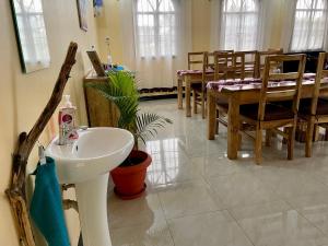 a bathroom with a sink and a dining room at Home Feeling Kilimanjaro in Moshi