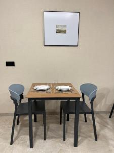 un tavolo in legno con sedie e una foto sul muro di URBAN Pensión a Melide