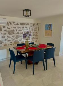 a dining room with a wooden table and blue chairs at Villa Portico in Budva
