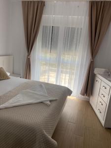 a bedroom with a bed and a dresser and a window at Apartament Grand Hill 1 in Oradea