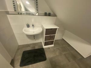 a white bathroom with a sink and a mirror at Colmdorf 14a Ferienhaus in Bayreuth +34 photos