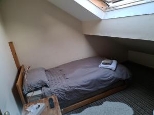 małe łóżko w małym pokoju z oknem w obiekcie Weaver's House B and B w Cardiff