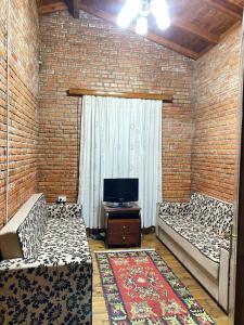 salon z 2 łóżkami i telewizorem w obiekcie Vila Mario Berat w mieście Berat