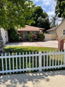 a white picket fence in front of a house at Summer Leaf in Reseda