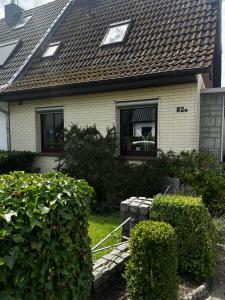 a house with a shingled roof and some bushes at Nord Haus in Kiel
