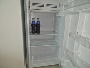 een open koelkast met twee flessen frisdrank erin bij Studio Joy2Sea in Mamaia Nord – Năvodari