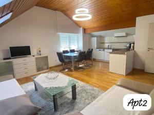 ein Wohnzimmer mit einem Tisch und einer Küche in der Unterkunft Minalya Home in Laufenburg
