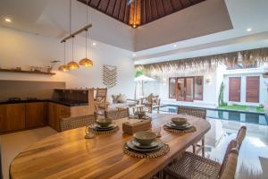 水明漾‎的住宿－Simple & Magical Villas. Villa Sambali llI，厨房以及带木桌和椅子的用餐室。
