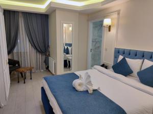 sypialnia z białym kotem leżącym na łóżku w obiekcie Galata istanbul Hotel w Stambule