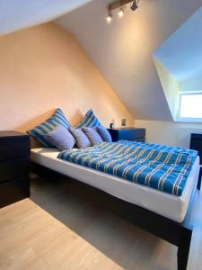 a large bed with blue pillows in a bedroom at Häuschen am Plenzer in Ingelheim am Rhein