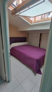 1 dormitorio con cama morada en el ático en Maison de ville port de Nice, en Niza