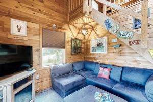 a living room with a blue couch in a cabin at The Grand Loon in Otis