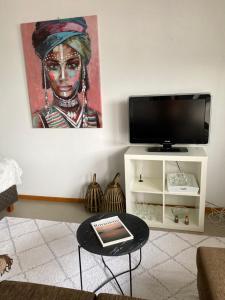a living room with a television and a painting on the wall at City Corner in Rovaniemi