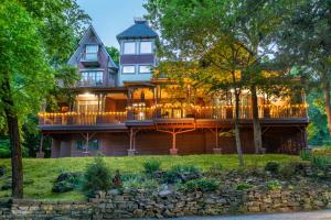 a large house with a large deck with lights on it at Angel at Rose Hall in Eureka Springs