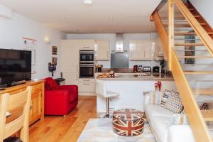 a kitchen and a living room with a red couch at Peels yard - Central Henley in Henley on Thames