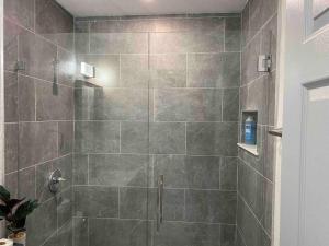 a bathroom with a shower with a glass door at Charming 2-Bedrooms Central Clearwater Apartment With Private Backyard in Clearwater +52 photos