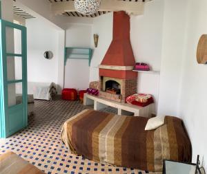 ein Schlafzimmer mit einem Kamin und einem Bett in einem Zimmer in der Unterkunft Riad Darko in Essaouira