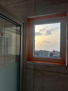 uma janela num quarto com vista para a cidade em Casa BB&Djassi em Ponta do Sol
