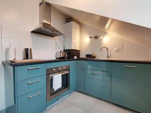 uma cozinha com armários azuis e um lavatório em Akela - Appartement à 12mn de Disneyland Paris ! em Bussy-Saint-Georges