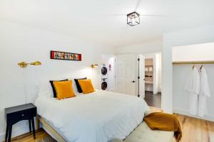 Fully Remodeled Saugerties Retreat on 7 Acres! في ساوغيرتيس: غرفة نوم بيضاء مع سرير كبير مع وسائد برتقالية