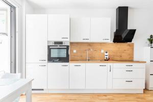 a kitchen with white cabinets and a sink at LA Studio in Maribor