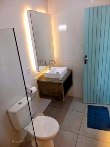 a bathroom with a toilet and a sink and a mirror at Pousada Eldorado Guarujá - in Guarujá