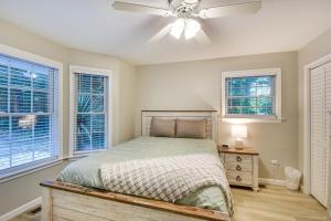 a bedroom with a bed with a ceiling fan and windows at Lake Hartwell Retreat with 2-Tier Dock and Boat Slip! in Seneca