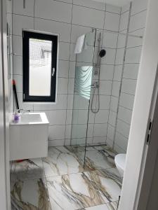 uma casa de banho com um chuveiro, um lavatório e um WC. em Apartamenty Pod Jodłami em Sarbinowo