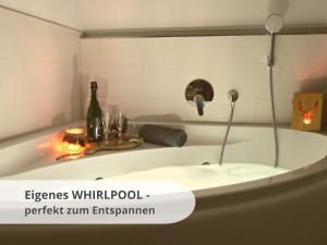 - une baignoire blanche avec une bouteille de vin dans l'établissement FeWo schwarzwaldschick Feldberg - Ideal für Wanderer & Biker & Naturliebhaber & Schwarzwald-Fans, à Feldberg