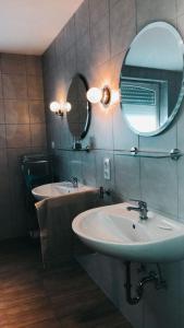 Baño con 2 lavabos y espejo en Monteurwohnung, en Emsbüren