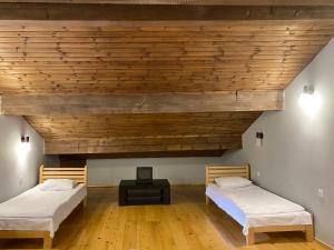 メスティアにあるAlpHouseApartment Mestiaの木製天井のドミトリールームのベッド2台分です。