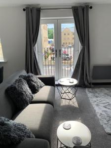 a living room with a couch and a large window at Mill Bank Apartment in Todmorden