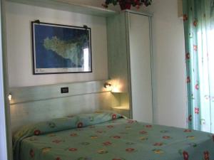 a bedroom with a bed and a painting on the wall at Costa Makauda Residence in Sciacca