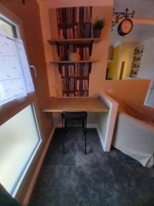 Habitación con escritorio con silla y estante con libros. en La Grelauderie 3 en Saintes